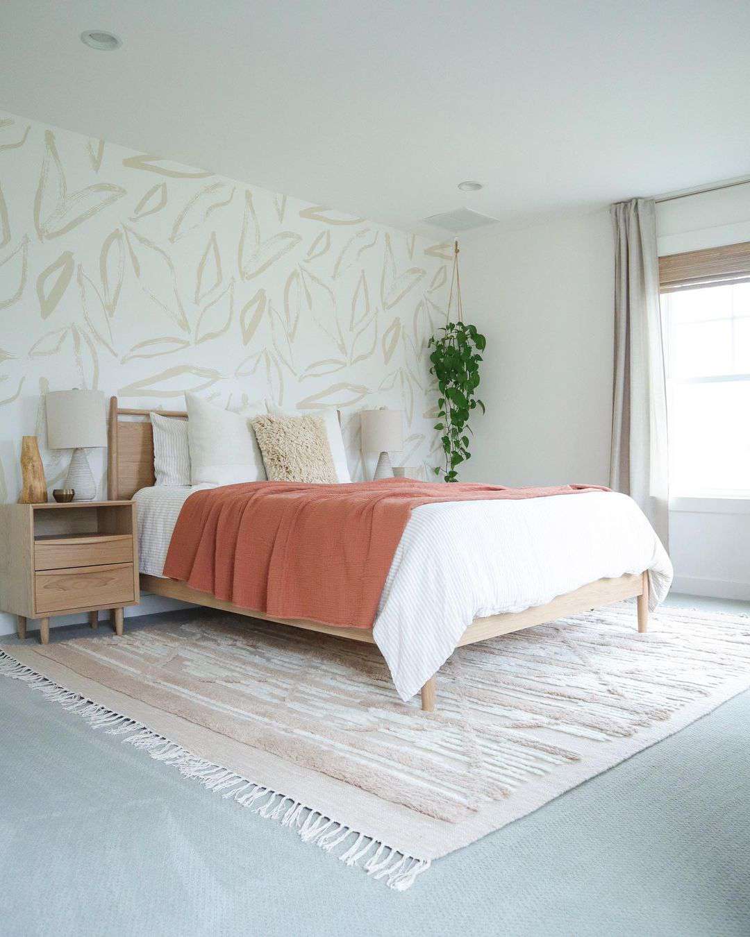 Bedroom with coral blanket and neutral palette