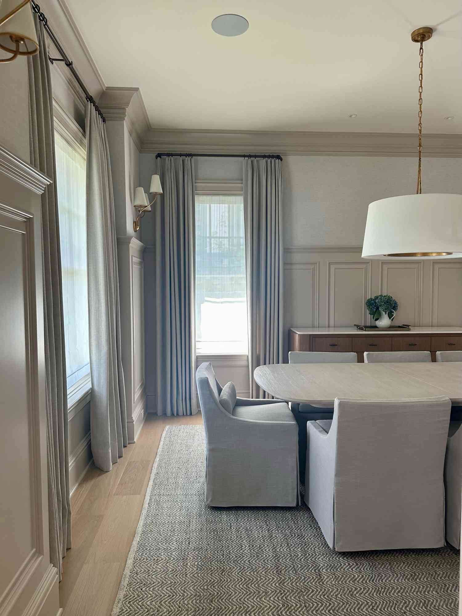 In progress modern contemporary dining room with tall millwork, drum pendant, and upholstered dining chairs