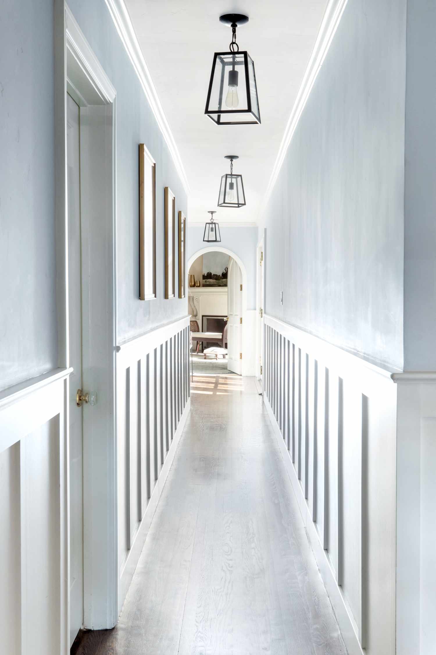 Long narrow hallway with light blue walls.